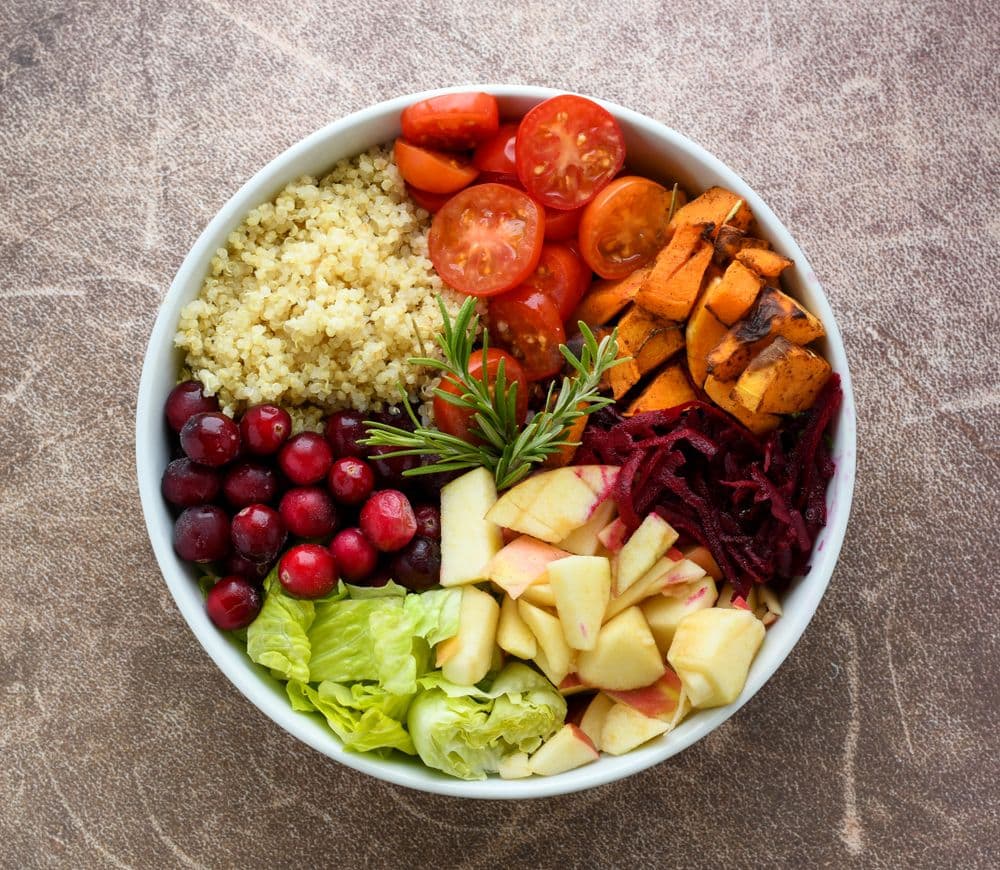 A colourful whole-food bowl of quinoa, vegetables and fruit